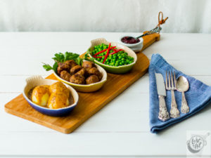 Mormor's Swedish Meatballs plated with potatoes, gravy and peas.